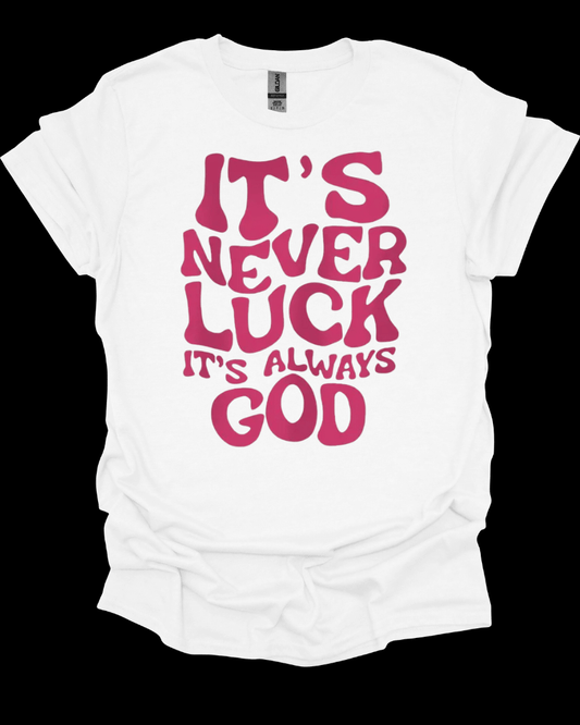 White It’s Never Luck It’s Always God Faith Graphic Tee with pink text 'IT'S NEVER LUCK IT'S ALWAYS GOD' on a black background